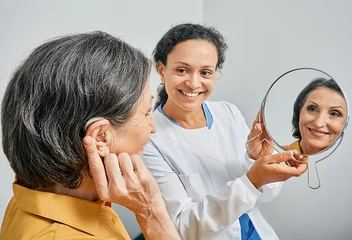 mujer adaptandose un audífono