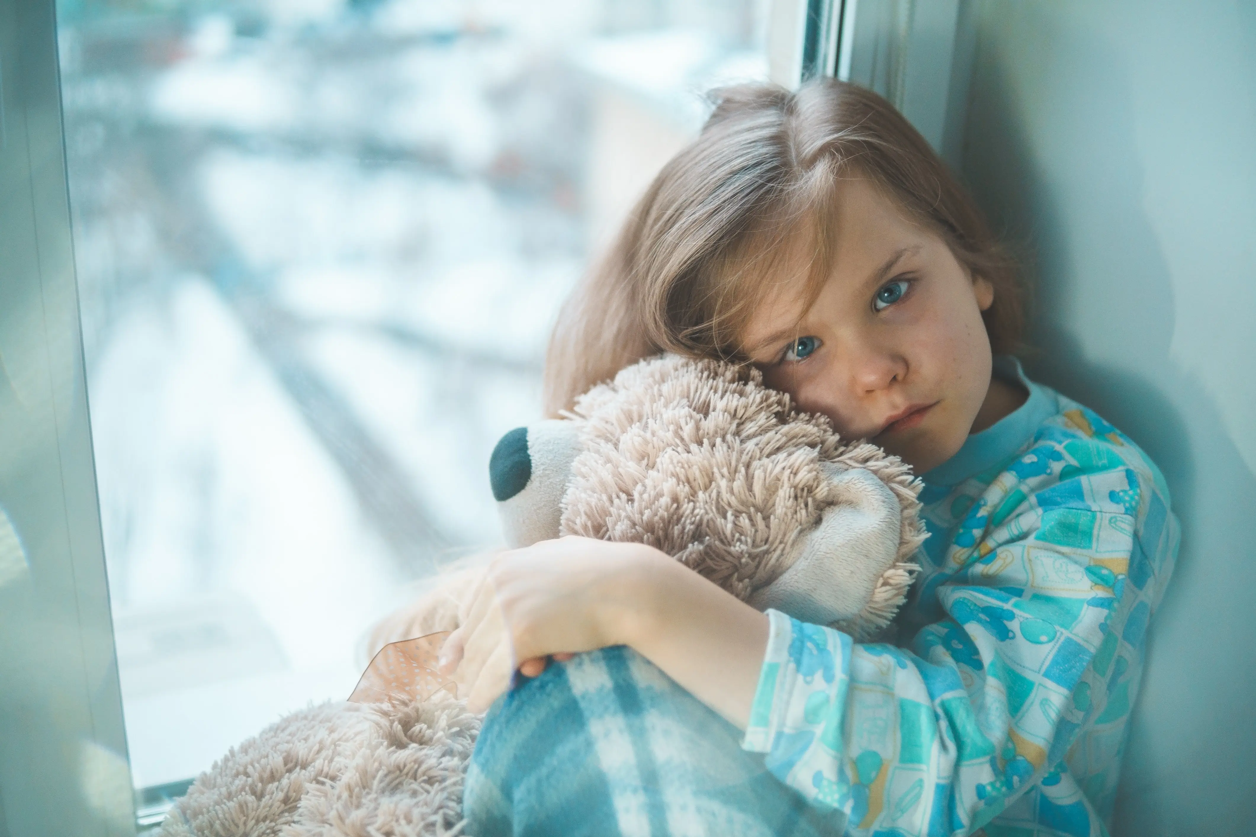 niña en la cama con osito